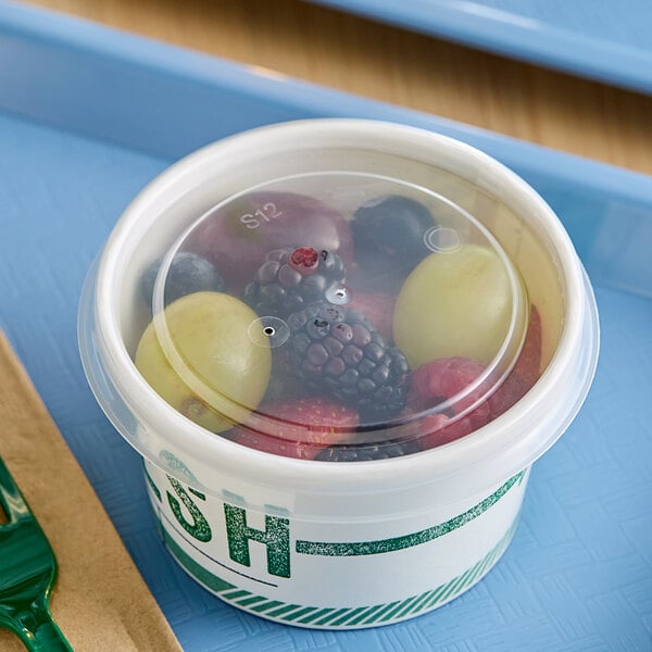 A clear plastic Innopak container of fruit on a table.