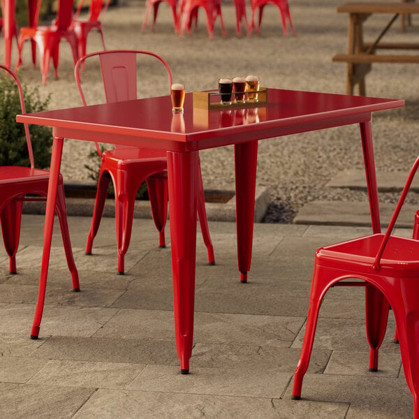 A red table and chairs on a patio.