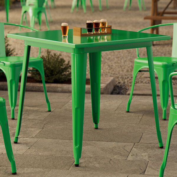 A Lancaster Table & Seating jade green table and chairs on a patio.