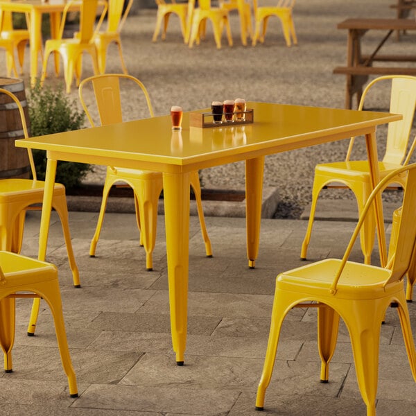 A yellow table and chairs on an outdoor patio.