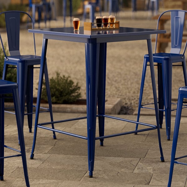 A Lancaster Table & Seating blue metal bar table with blue legs.