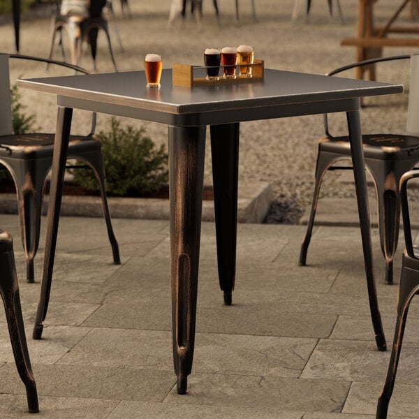 A Lancaster Table & Seating outdoor table with glasses of beer on it.