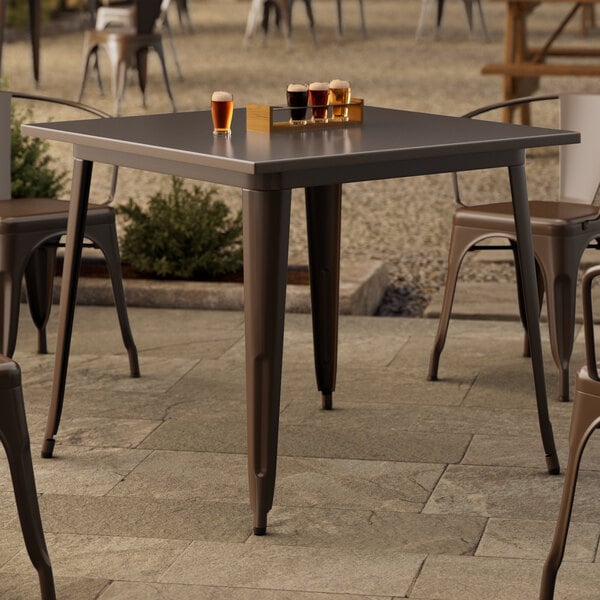 A Lancaster Table & Seating outdoor table with glasses of beer on it.