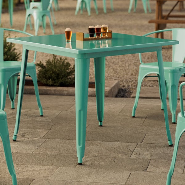 A Lancaster Table & Seating outdoor table and chairs on a patio.