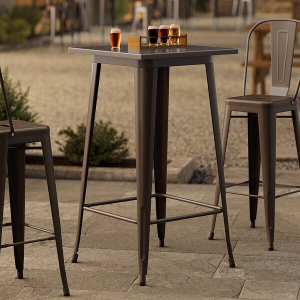 A Lancaster Table & Seating copper bar height table on an outdoor patio.