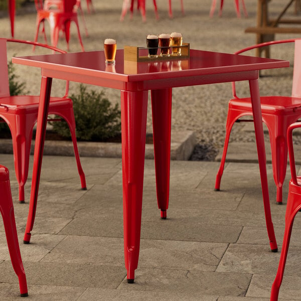 A Lancaster Table & Seating Ruby Red Table with chairs on a patio.