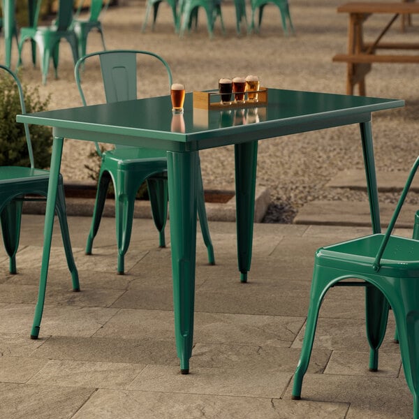 A green table and chair on a patio.