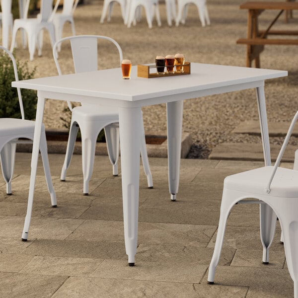 A Lancaster Table & Seating white table and chair on an outdoor patio.