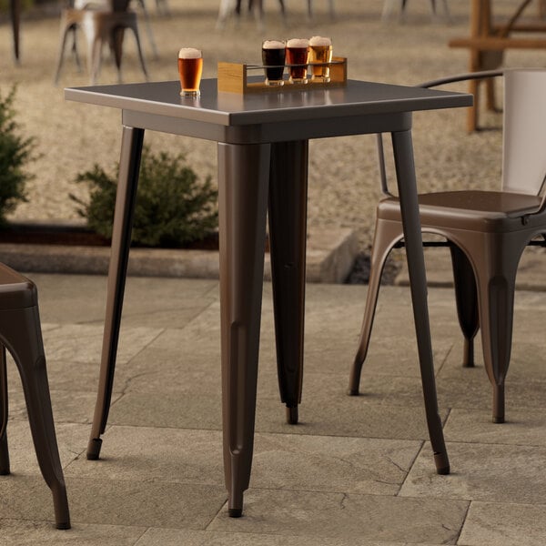 A Lancaster Table & Seating outdoor table with drinks on it.