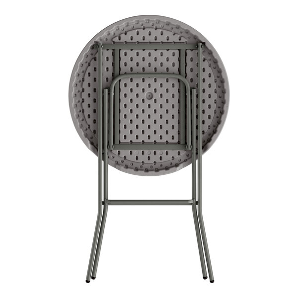 A round gray heavy-duty plastic folding table with gray metal legs in a folded position.
