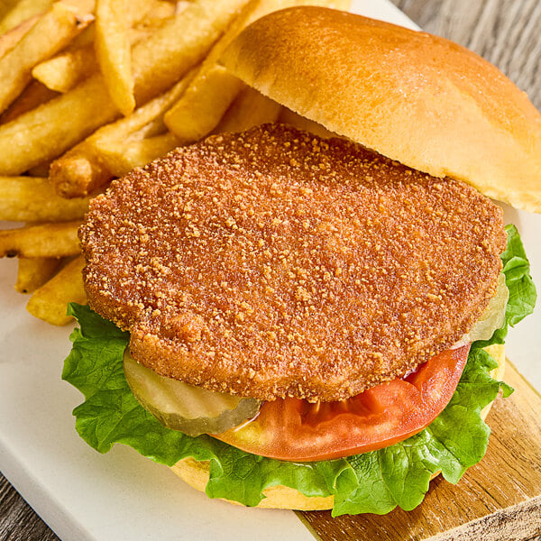 A Rebellyous spicy plant-based chicken patty on a plate with fries.