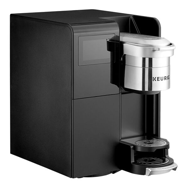 A black Keurig commercial single serve coffee maker with a silver cup and silver lid.