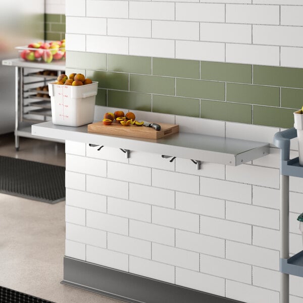 A Regency aluminum wall mount shelf with food items on it.