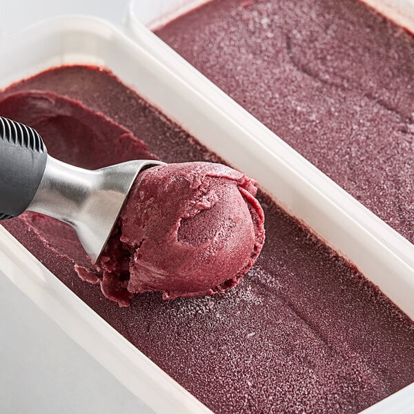 A scoop of red Sambazon Organic Acai in a container.