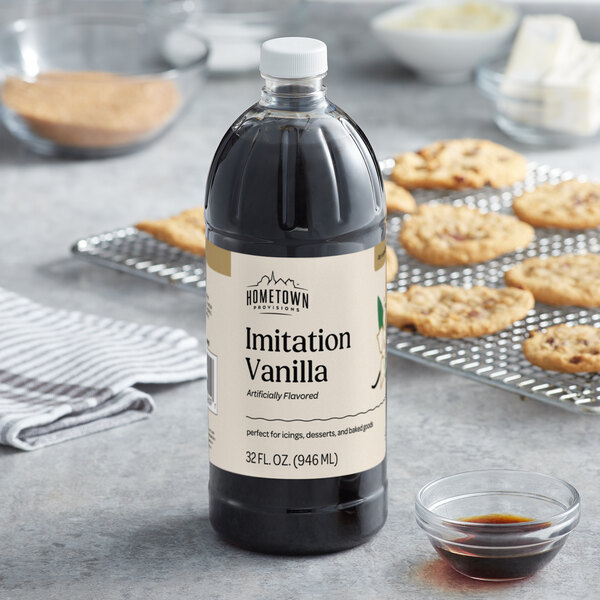 A bottle of Hometown Provisions Imitation Vanilla on a counter next to a bowl of brown liquid.