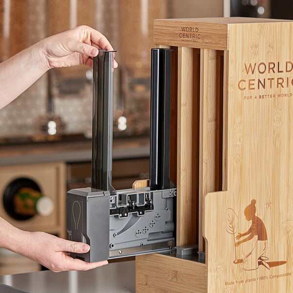 A person opening a box with a World Centric Touchless Cutlery Dispenser.