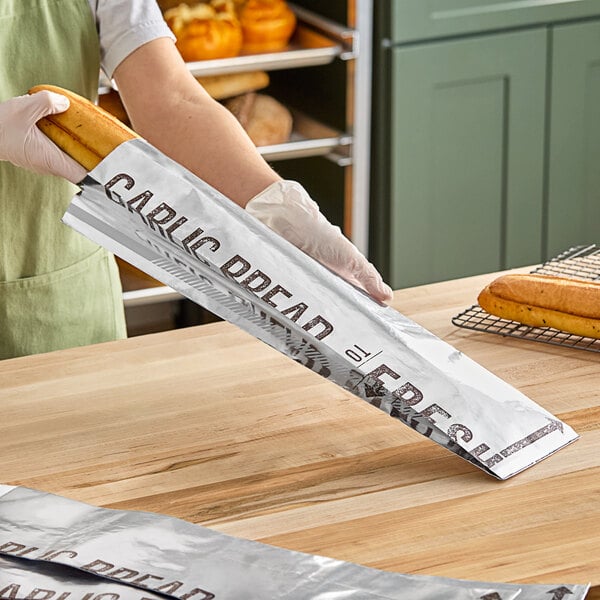 A woman using an Innopak foil bag to hold a large loaf of bread.