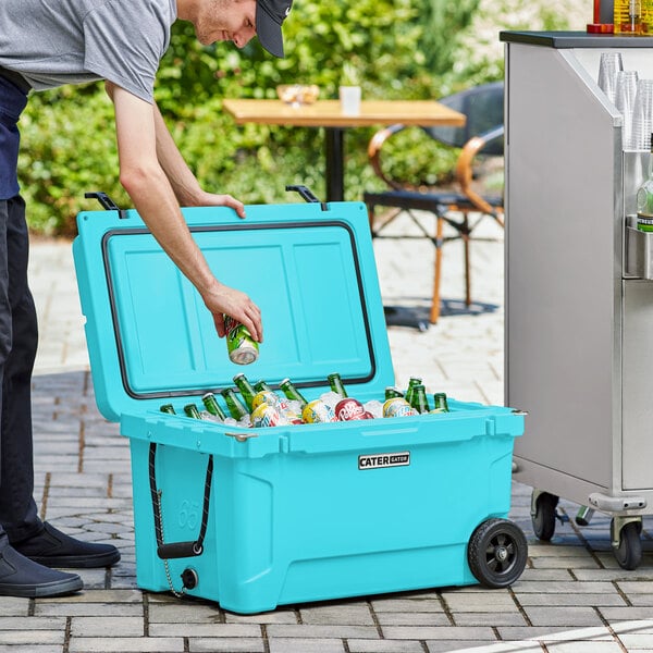 A man putting a can into a CaterGator outdoor cooler.
