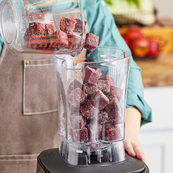 A person pouring Live Pure Strawberry Acai smoothie cubes from a blender.