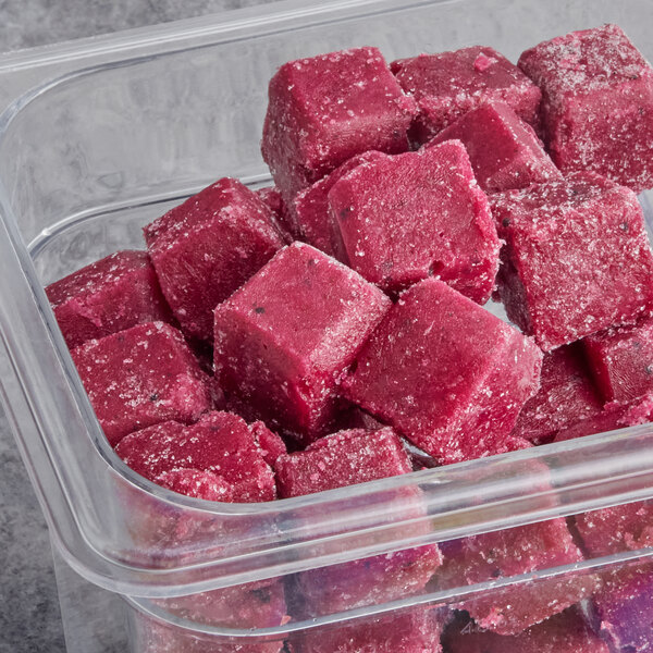 A plastic container filled with red Live Pure Pitaya Passion Fruit smoothie cubes.