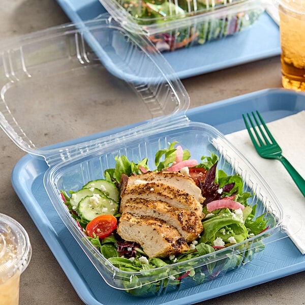 A clear plastic Choice clamshell container with sliced chicken, salad, and a drink on a plate.