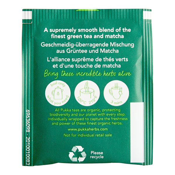 A green and gold Pukka Supreme Matcha Green Tea packet with a green tea bag inside.