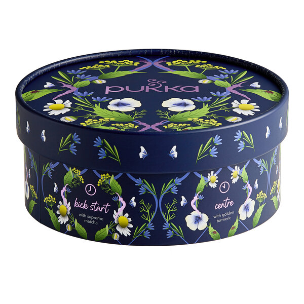A round blue Pukka Organic Workday Wellness Tea variety pack with flowers and leaves on it.