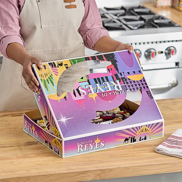 A woman holding a Southern Champion bakery box with a window.