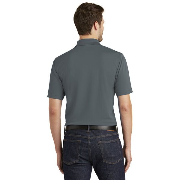 A man wearing a graphite Port Authority polo shirt.