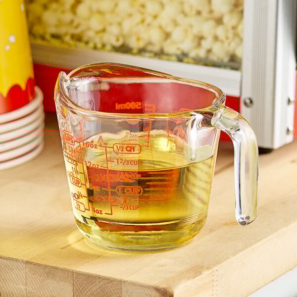 A measuring cup with LouAna Premium Canola Popping Oil in it.