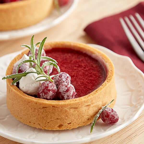 A dessert with whole cranberries and whipped cream on a plate.