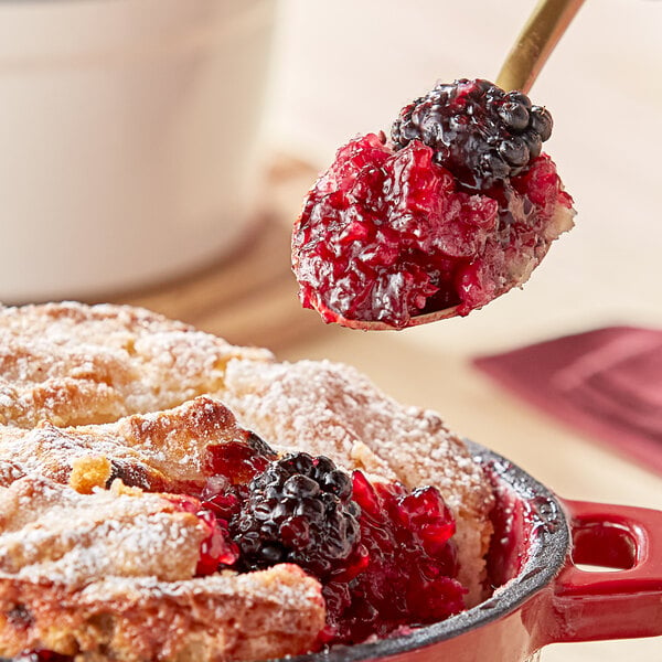 A spoonful of Wyman's frozen blackberries on a dessert.