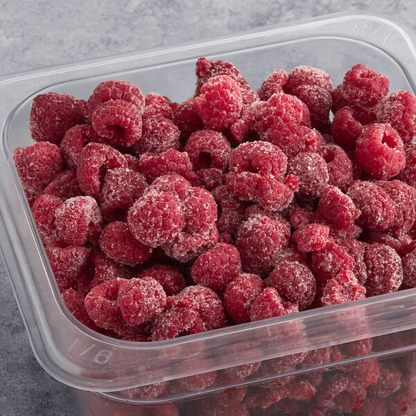 A plastic container of Wyman's frozen red raspberries.