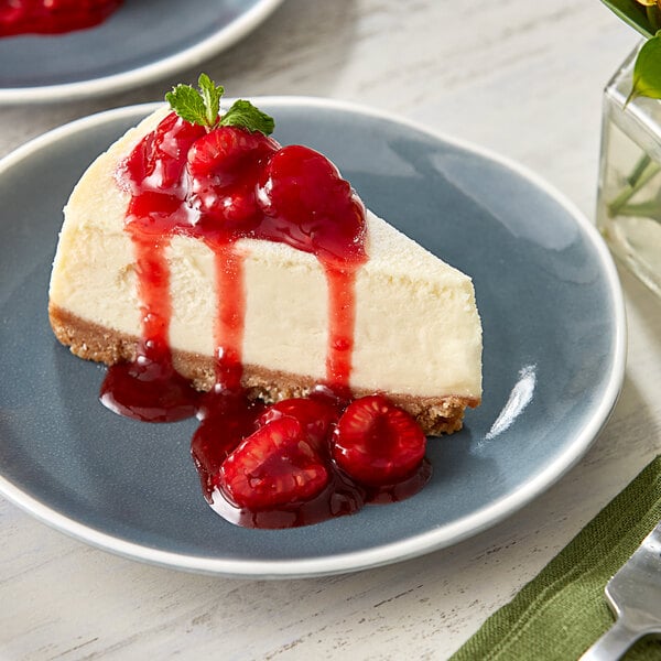 A slice of cheesecake with raspberries on top.