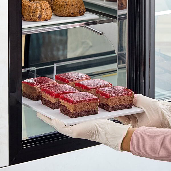 A person holding a plate with a White Toque gluten-free vegan chocolate and berry cake slice.