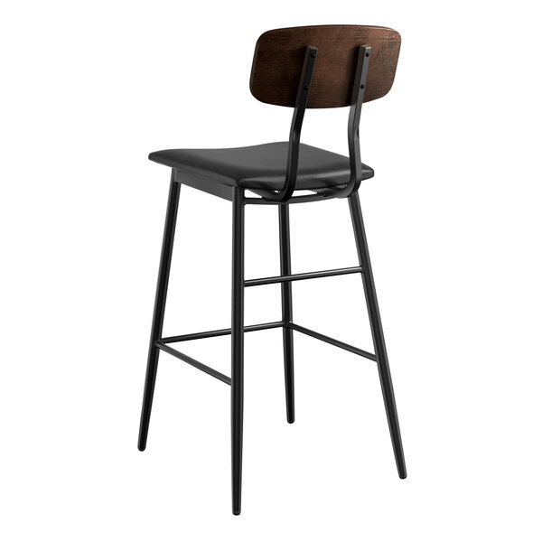 A black bar stool with a black vinyl seat and wood backrest.
