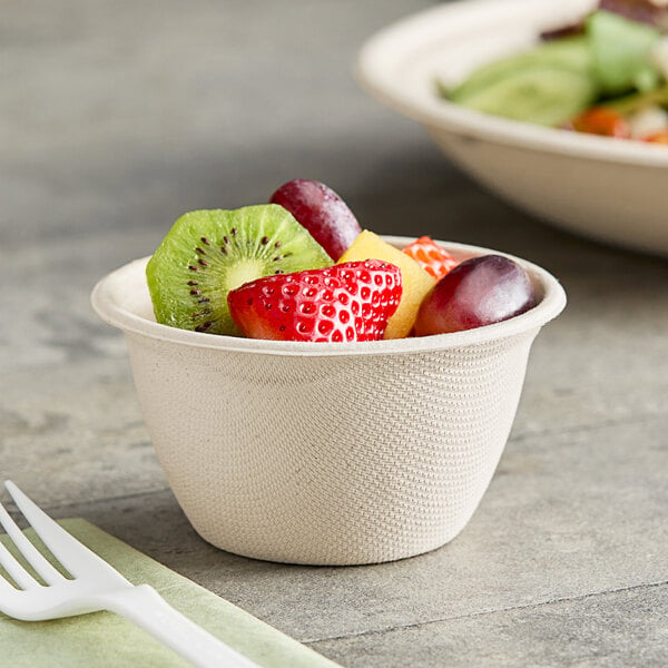 A World Centric compostable fiber bowl filled with fruit on a table.