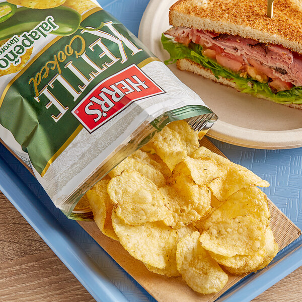 A sandwich with Herr's Jalapeno Potato Chips on a plate.