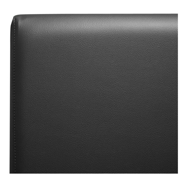 A close up of a black leather surface on a QA Group restaurant booth.