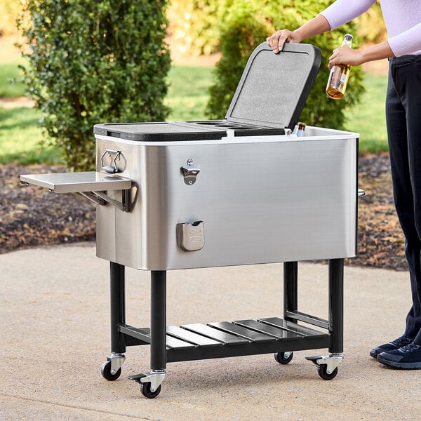 A woman opening a Choice stainless steel beverage cooler cart.