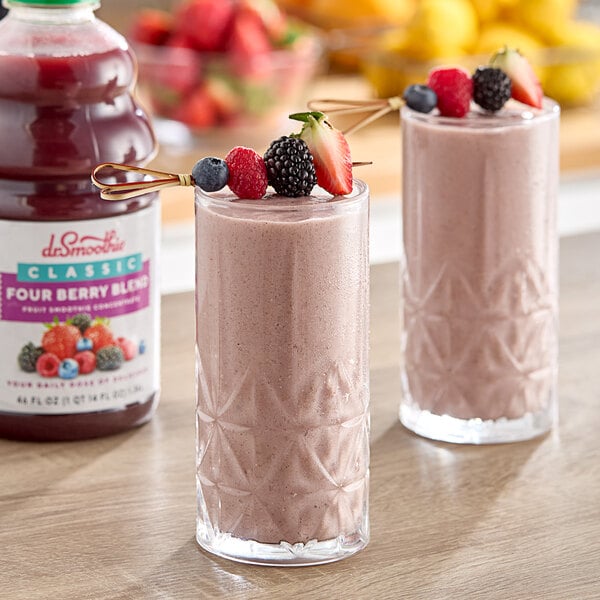 Two glasses of Dr. Smoothie Four Berry fruit smoothie with strawberries on top.