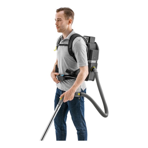 A person wearing a Karcher BVL 5/1 BP cordless backpack vacuum.