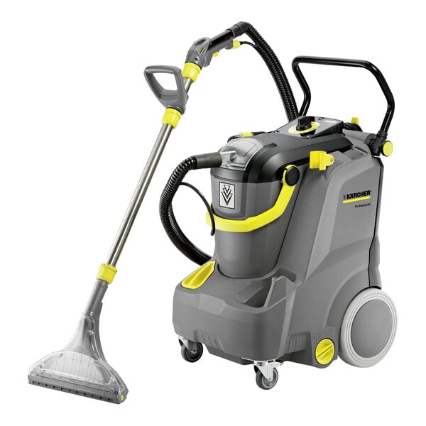 A Karcher Puzzi 30/4 carpet extractor with a grey and yellow machine with a handle.