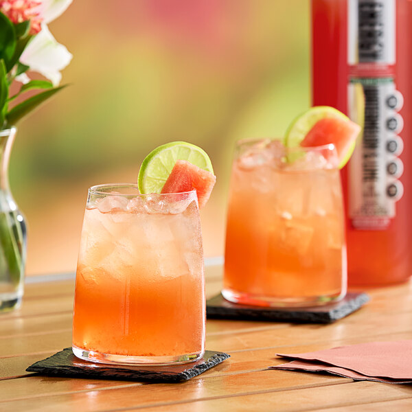 Two glasses of SHOTT Watermelon and Lime energy drink on a table.
