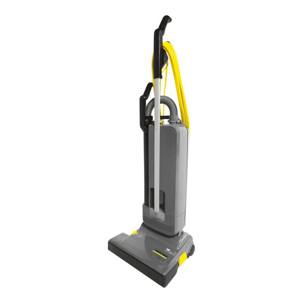 A grey and yellow Karcher CVU 36/1 HEPA upright vacuum cleaner with accessories.