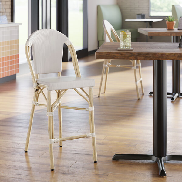 A gray counter height outdoor side stool with a woven seat and backrest, featuring a light wood-look frame.