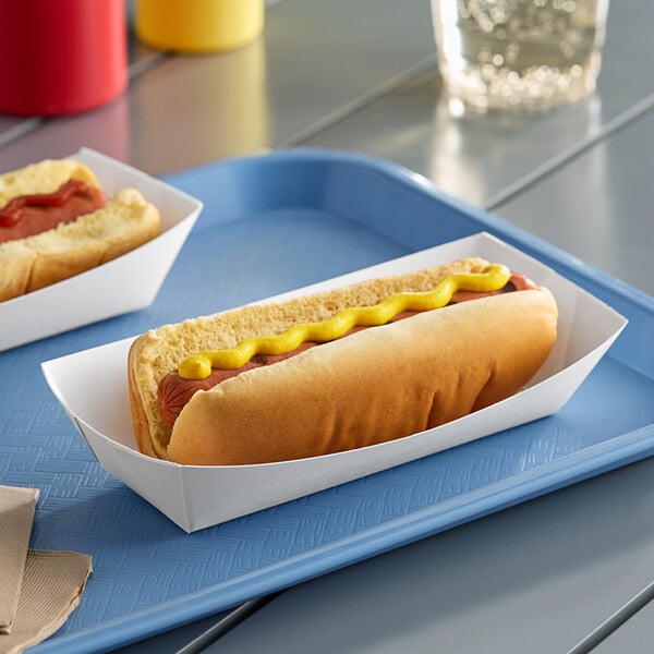 A hot dog in a white paper tray with mustard.