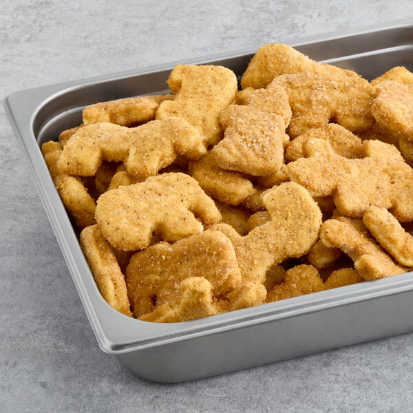 A pan of Brakebush Zoo Crew chicken nuggets on a table in a school kitchen.