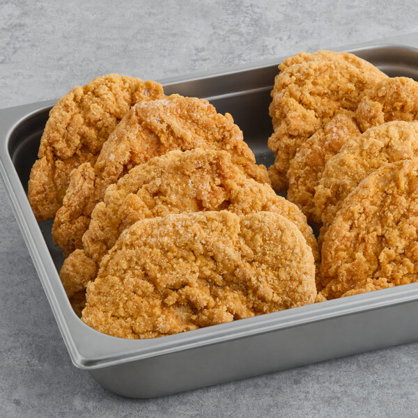 A pan filled with Brakebush Spicy Crispy Breaded Chicken Breast Fillets.
