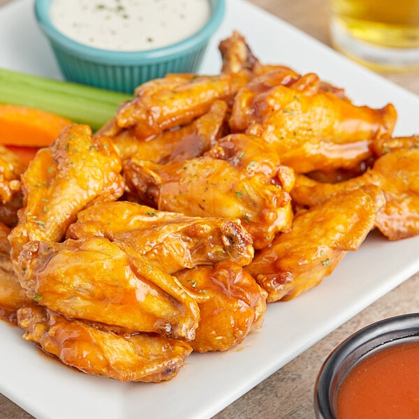 A plate of chicken wings with Frank's RedHot Mango Habanero Wings Sauce and dips.